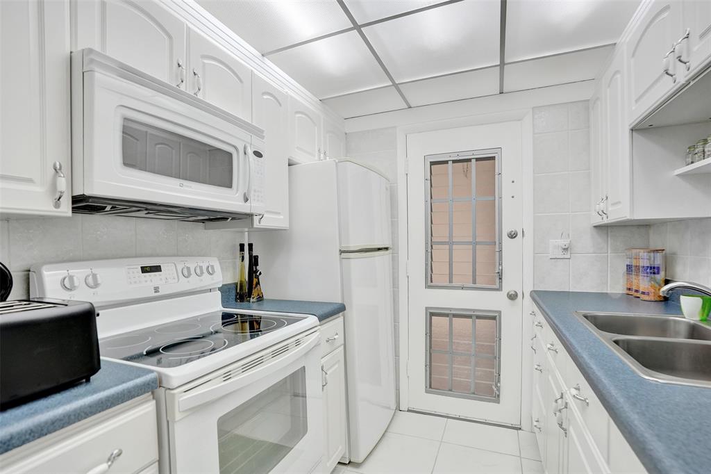 17001 Northeast 13th Avenue, Unit 104 Miami, FL 33162 - Photo 4 of 41 a kitchen with stainless steel appliances granite countertop a sink stove and refrigerator