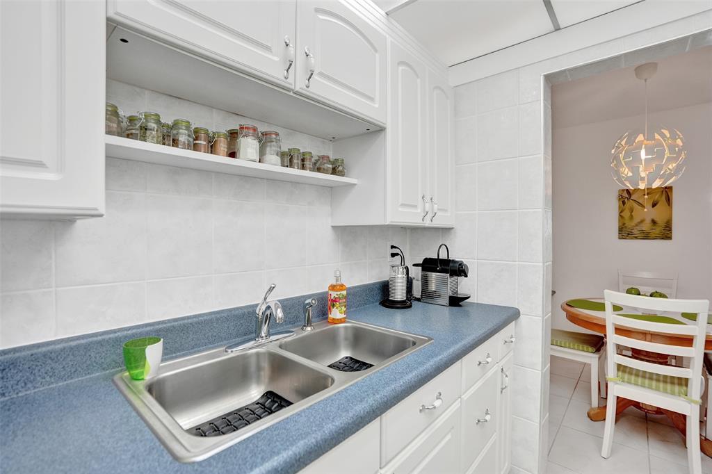 17001 Northeast 13th Avenue, Unit 104 Miami, FL 33162 - Photo 6 of 41 a kitchen with white cabinets and a sink