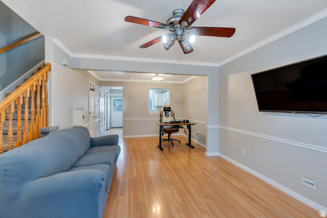 986 Independence Avenue Provo, UT 84604 - Photo 4 of 29 Open-concept living space with wood-finish flooring, a ceiling fan with integrated lighting, and a staircase featuring a wood banister