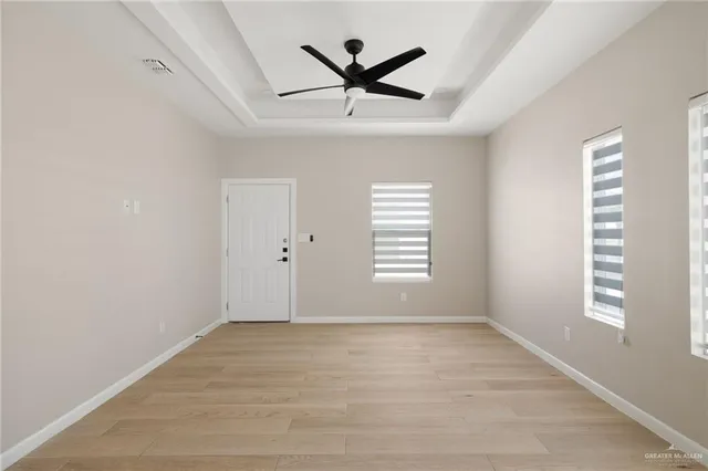 an empty room with window and ceiling fan
