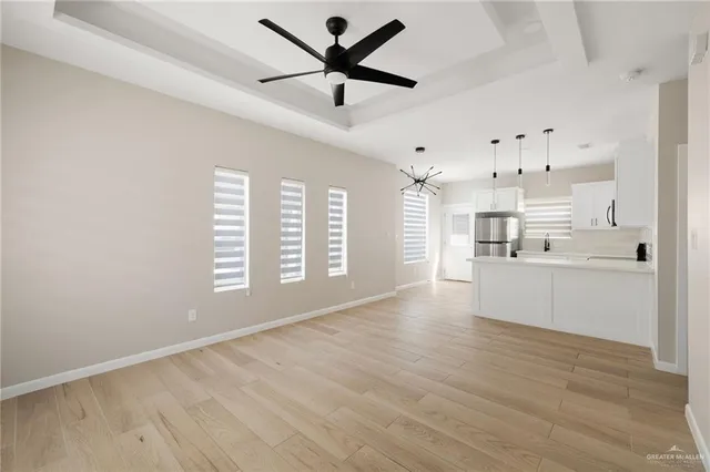 a view of an empty room with window and wooden floor