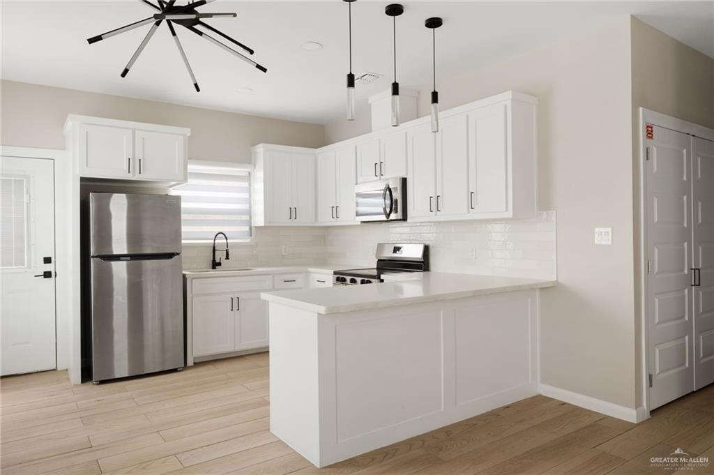 5812 Northwestern Avenue, Unit 3 Mission, TX 78573 - Photo 5 of 10 a kitchen with stainless steel appliances granite countertop a refrigerator a sink a stove and white cabinets