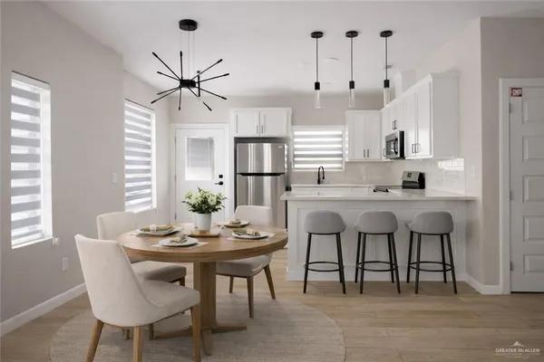 a kitchen with stainless steel appliances kitchen island a table and chairs in it