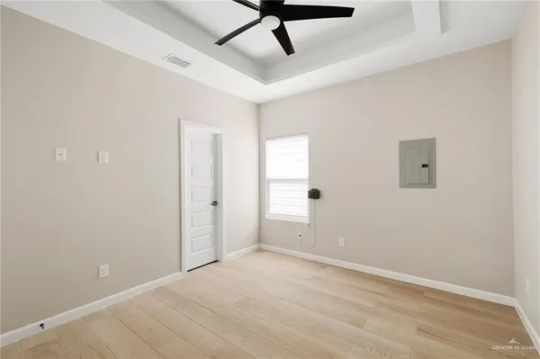 an empty room with a ceiling fan and carpet
