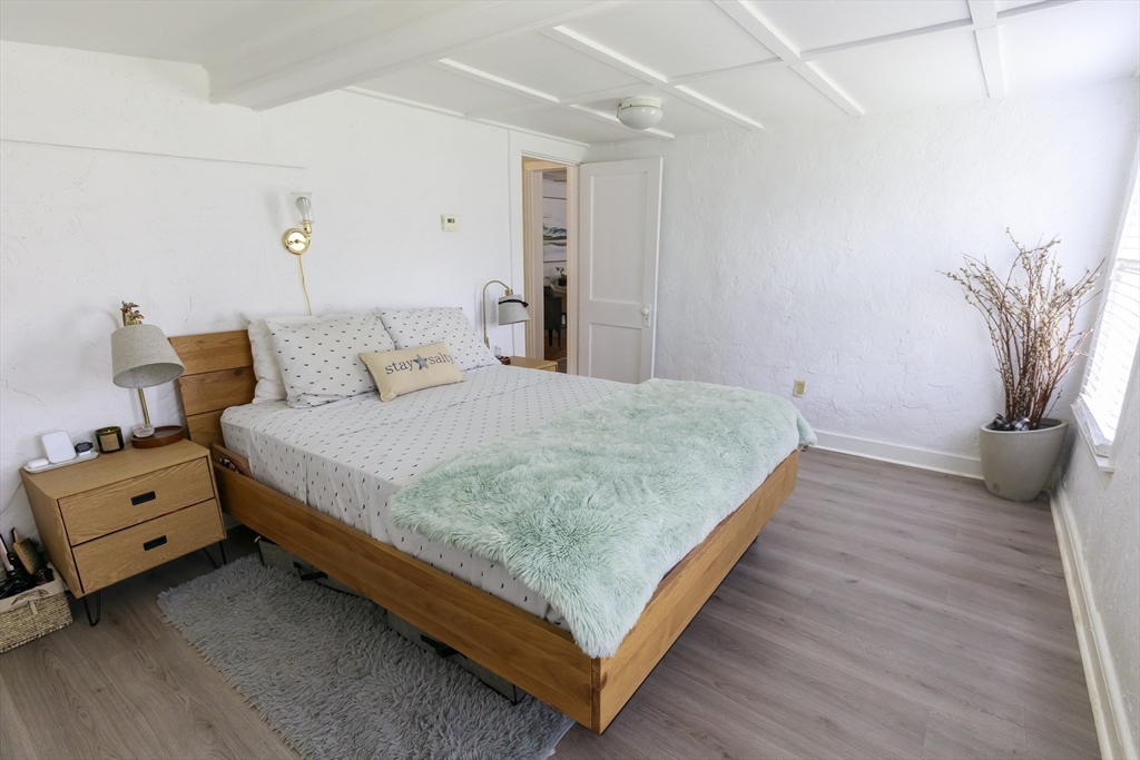 70 Cottage Road Newbury, MA 01951 - Photo 13 of 25 a bedroom with a bed and a potted plant