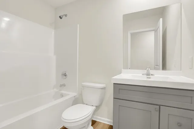 a bathroom with a granite countertop sink a toilet and a bathtub