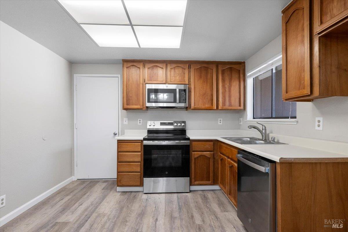 987 Daniel Street Fairfield, CA 94533 - Photo 11 of 36 a kitchen with stainless steel appliances granite countertop wooden cabinets a stove top oven a sink and dishwasher