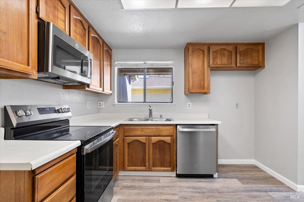 987 Daniel Street Fairfield, CA 94533 - Photo 12 of 36 a kitchen with stainless steel appliances a stove a sink and a microwave