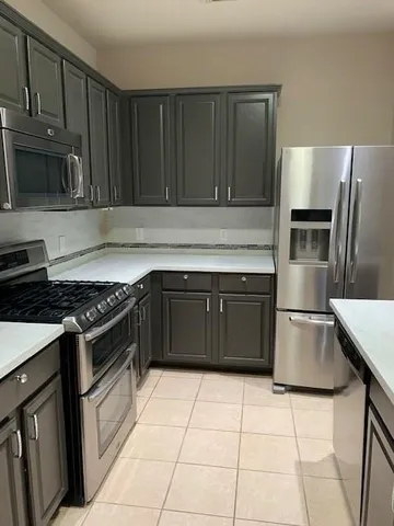 a kitchen with granite countertop a stove and a refrigerator