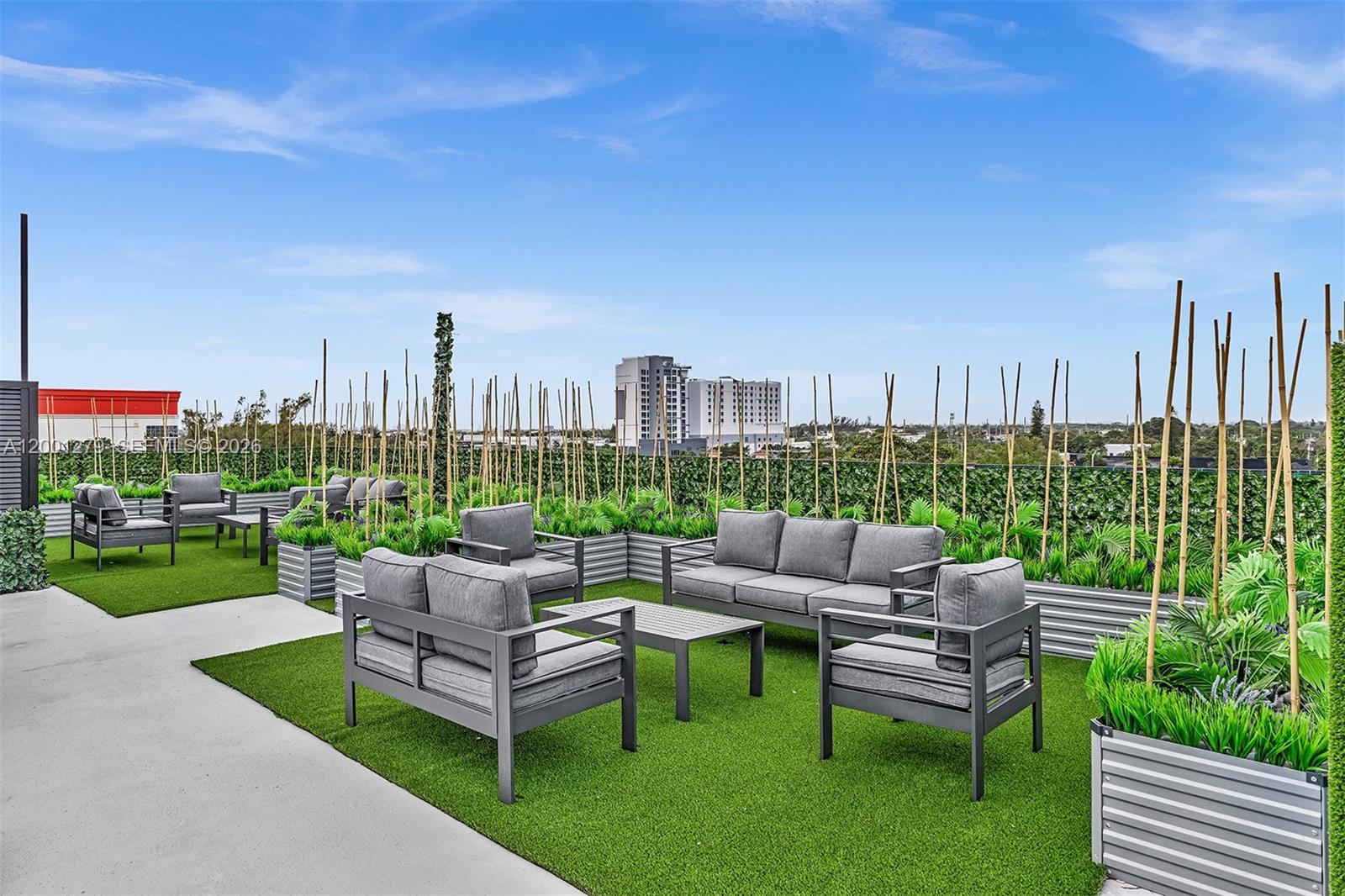 2100 Miami Road, Unit 403 Fort Lauderdale, FL 33316 - Photo 43 of 44 a view of a patio with couches and a table and chairs with garden