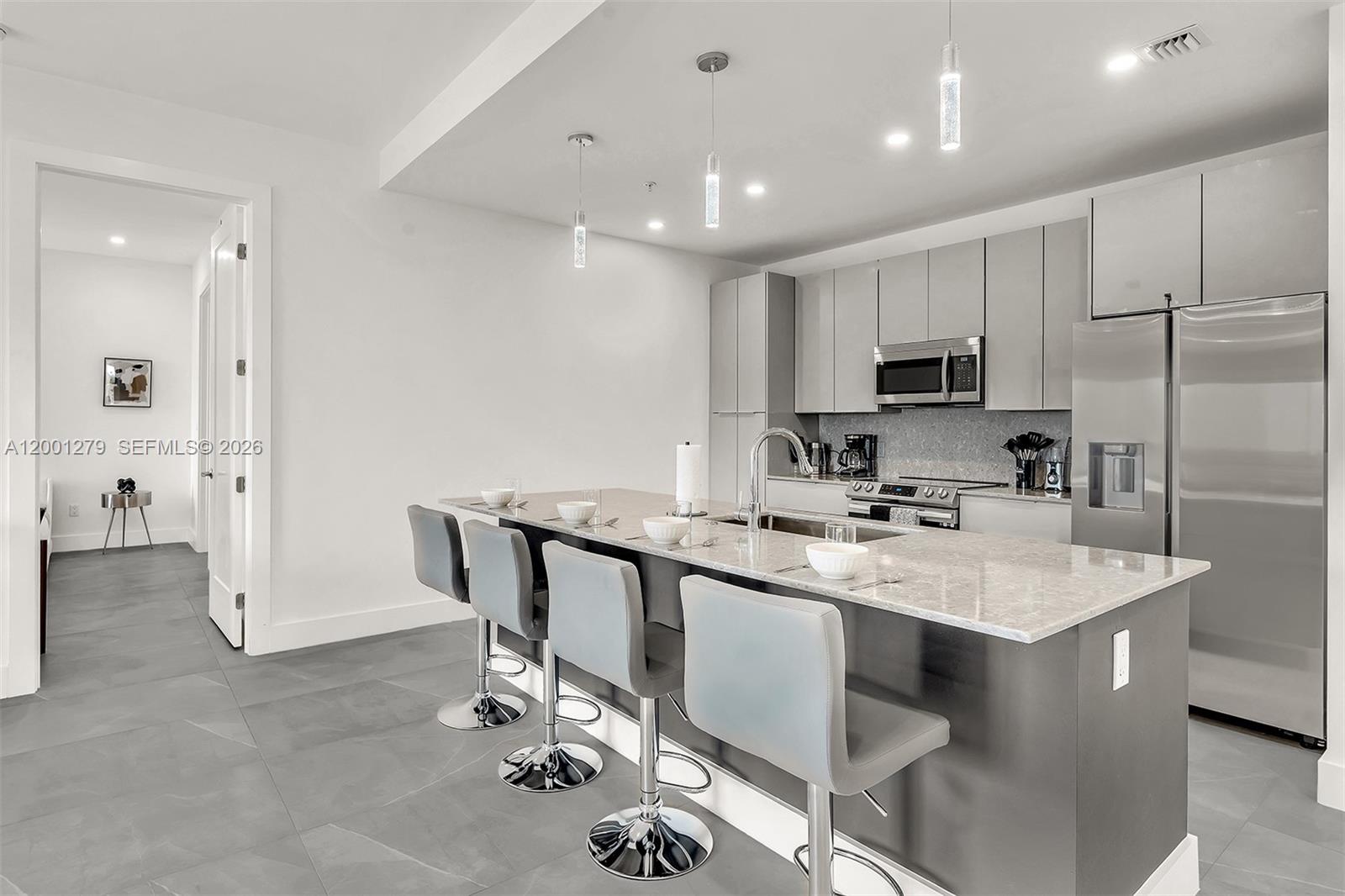 2100 Miami Road, Unit 403 Fort Lauderdale, FL 33316 - Photo 6 of 44 a kitchen with kitchen island a sink appliances and cabinets