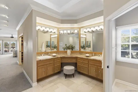a bathroom with a double vanity sink a toilet a mirror and a bathtub