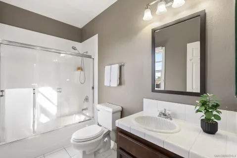 a bathroom with a sink toilet mirror and shower