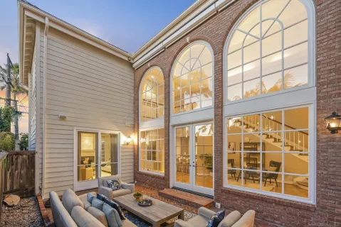 a view of a living room filled with furniture and large windows