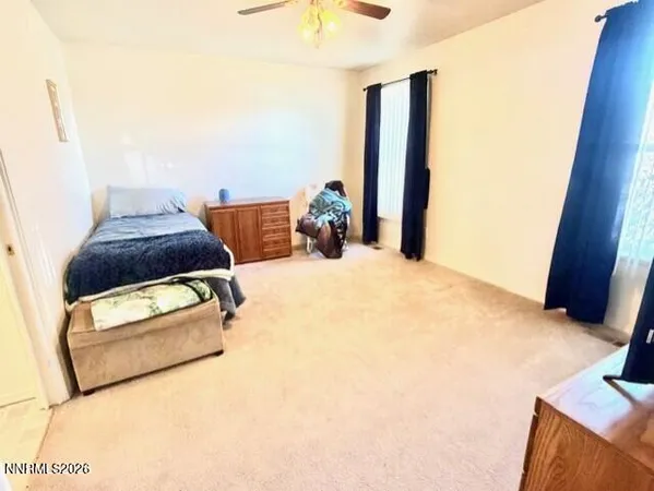 a bedroom with a bed and a flat tv screen on dresser