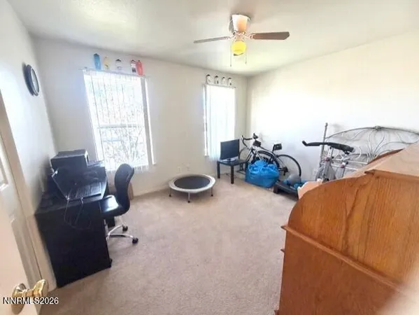 a view of a workspace with furniture and a window