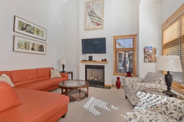 a living room with furniture a flat screen tv and a fireplace