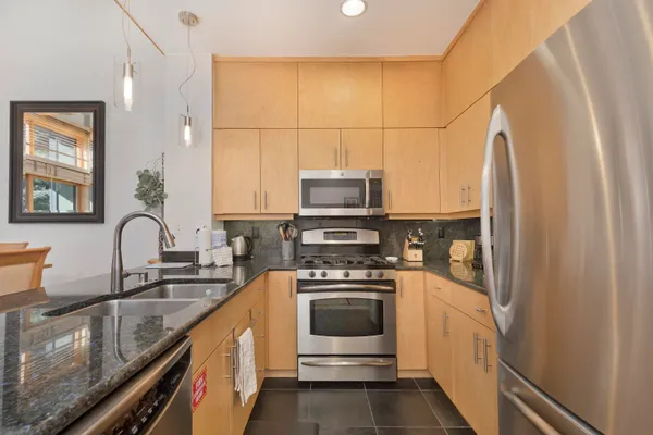 a kitchen with stainless steel appliances a stove a sink and a refrigerator