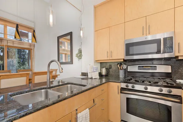 a kitchen with stainless steel appliances granite countertop a sink stove and microwave