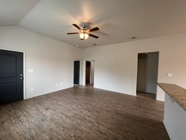 a view of empty room with wooden floor