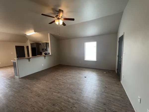 a view of a livingroom with wooden floor and a ceiling fan