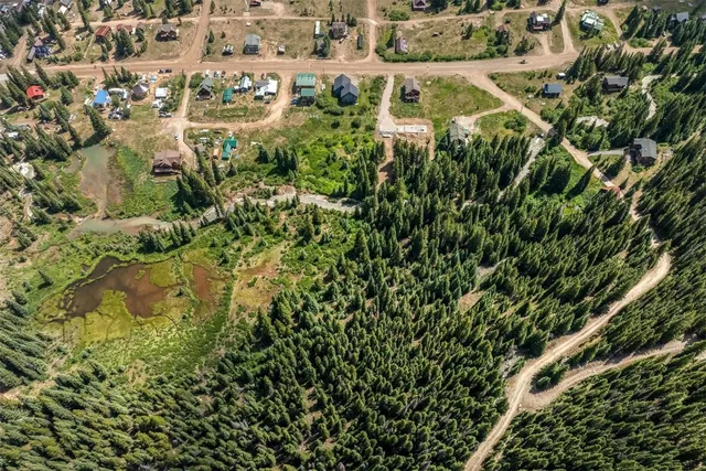 an aerial view of residential houses with outdoor space and trees