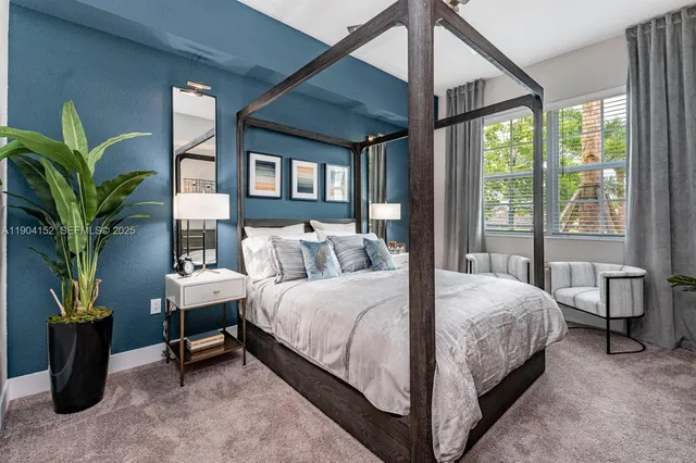 a bedroom with a large bed and a potted plant