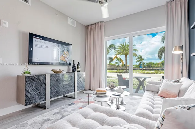 a living room with furniture and a floor to ceiling window