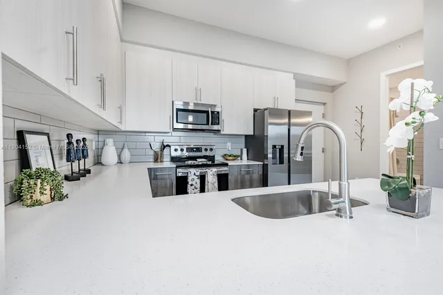 a kitchen with stainless steel appliances a sink a microwave a stove and refrigerator