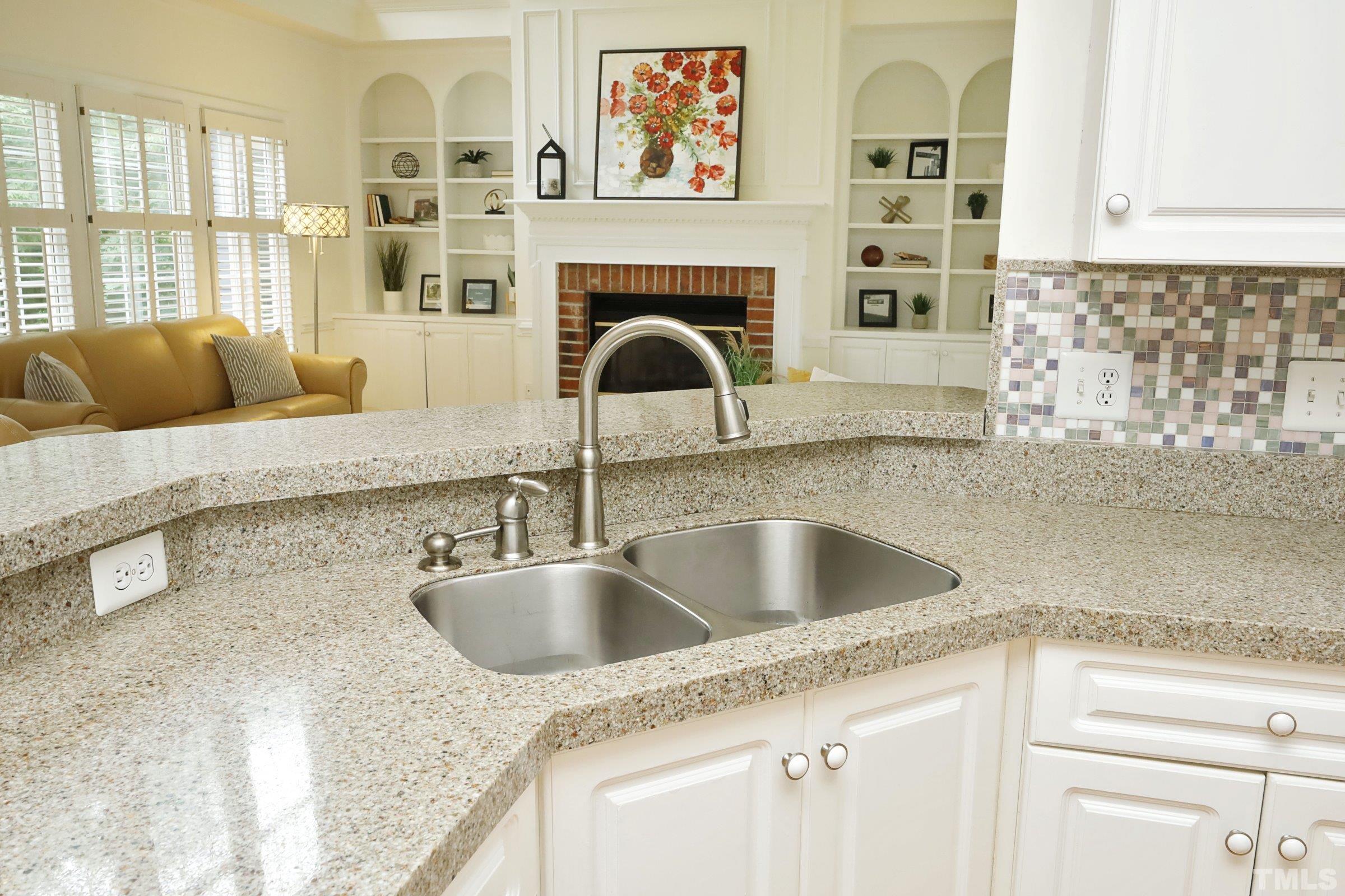 101 Modena Drive Cary, NC 27513 - Photo 21 of 57 a kitchen with a granite countertop sink and natural light