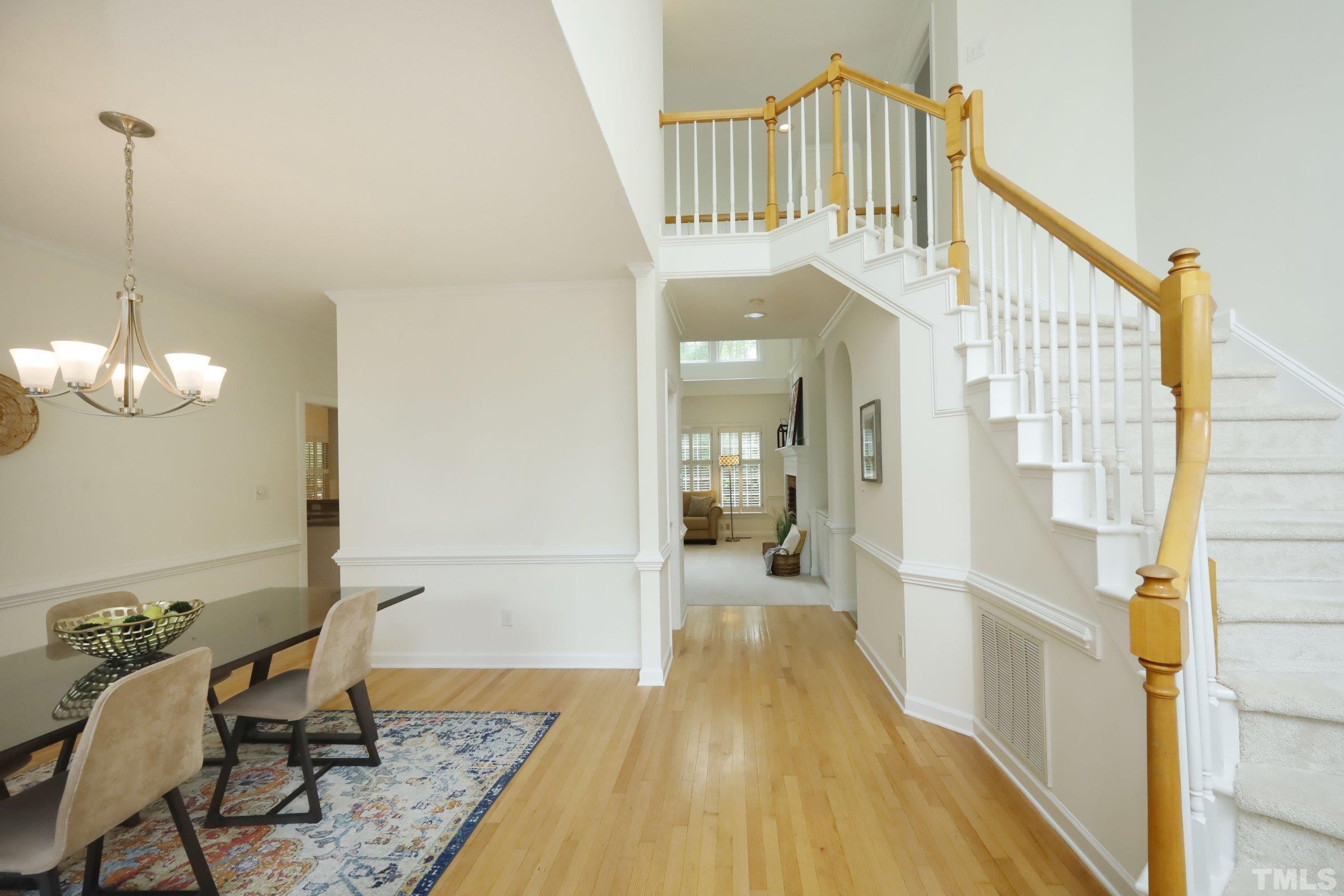 101 Modena Drive Cary, NC 27513 - Photo 6 of 57 a view of a hallway with a livingroom with furniture wooden floor and a chandelier
