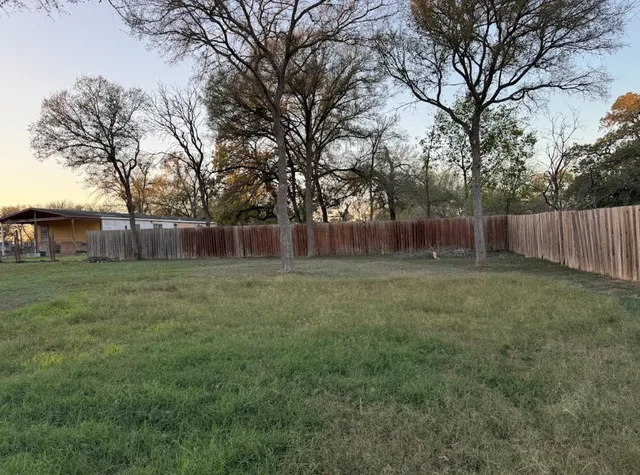 a view of a house with a yard and wooden deck
