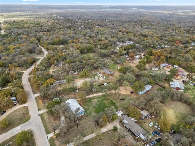 a front view of a building with lot of cars and trees