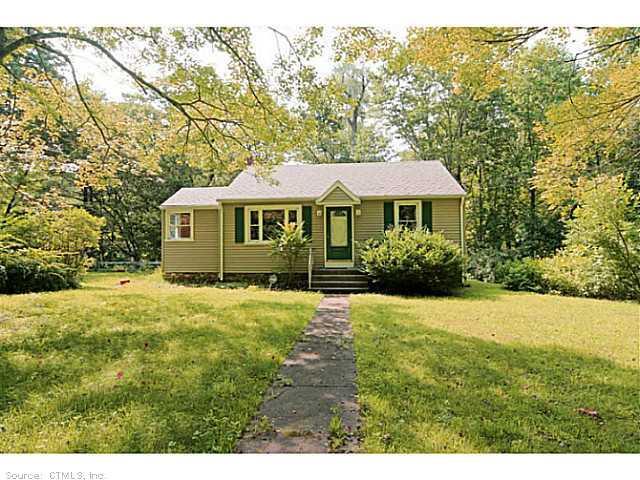 a front view of a house with a yard and trees