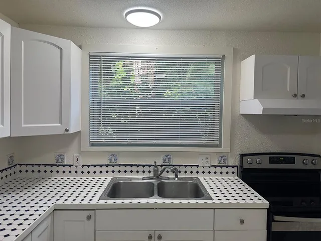 a view of a park with a slide and large trees