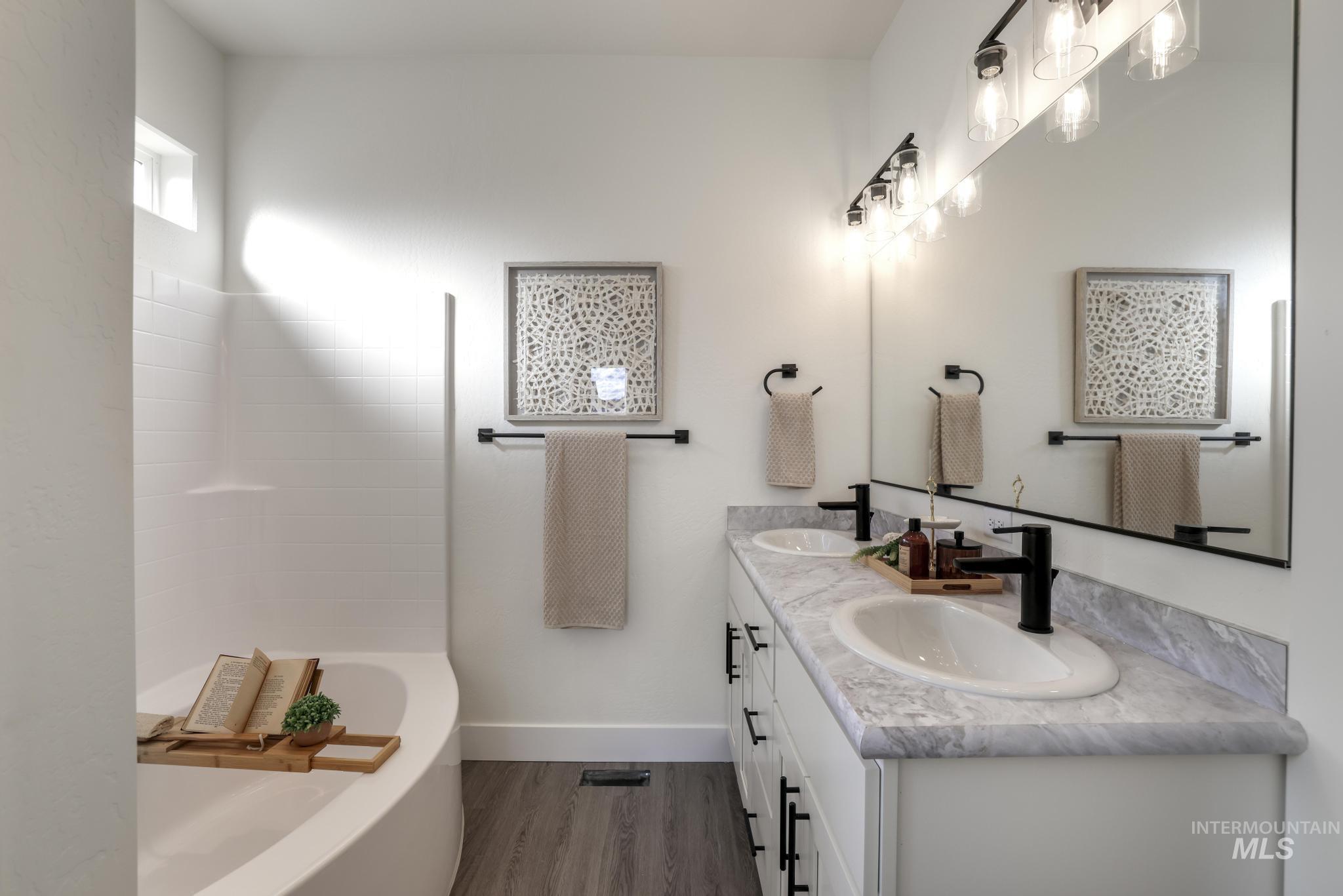 921 Adamite Road Kimberly, ID 83341 - Photo 4 of 25 Bathroom with double vanity, wood finished floors, and shower / washtub combination