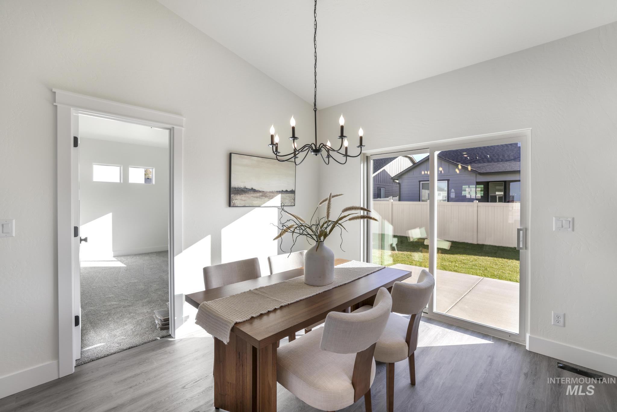 921 Adamite Road Kimberly, ID 83341 - Photo 9 of 25 Dining room with lofted ceiling, wood finished floors, and a chandelier