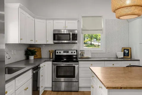 a kitchen with granite countertop a sink a stove and microwave