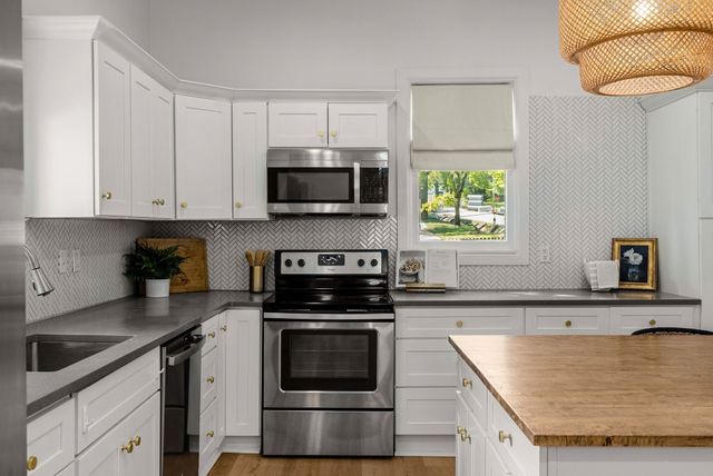 a kitchen with granite countertop a sink a stove and microwave