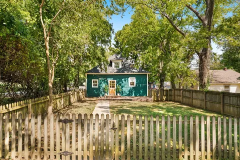 a view of brick house with a large tree