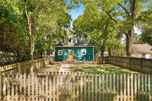 a view of brick house with a large tree