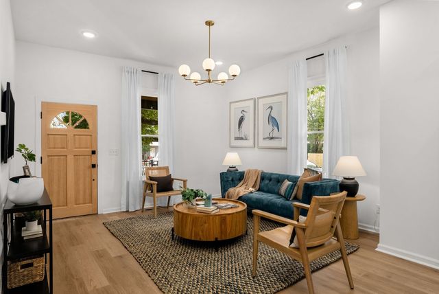 a living room with furniture chandelier and a window