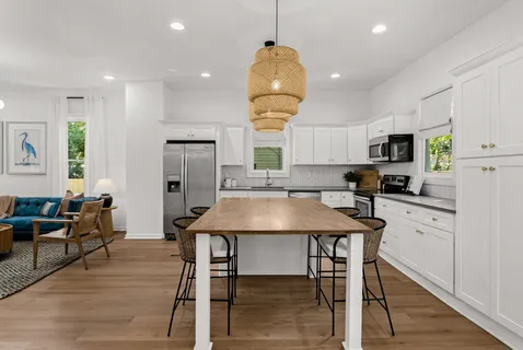 a kitchen with a table chairs refrigerator and microwave
