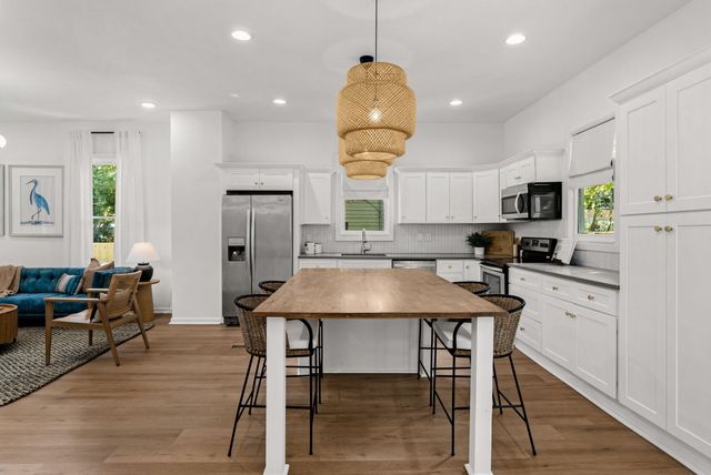 a kitchen with a table chairs refrigerator and microwave
