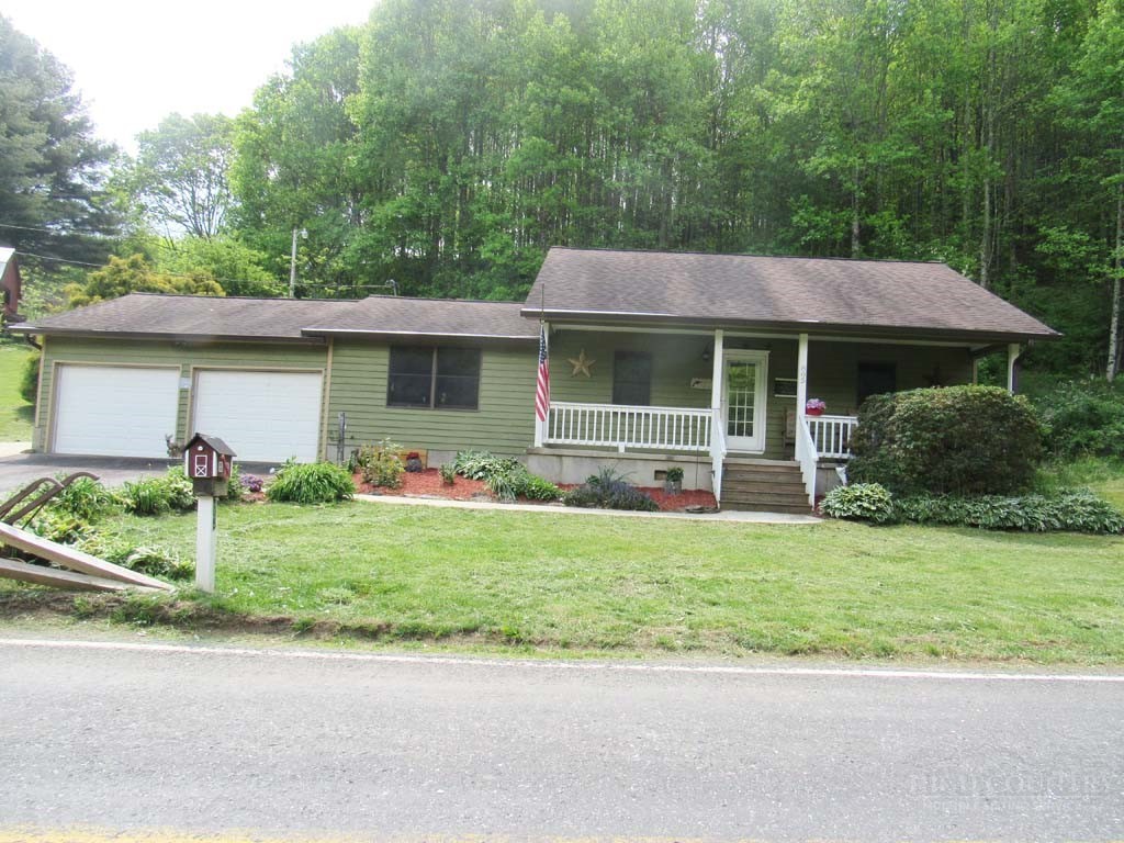 805 Ed Little Road Warrensville, NC 28693 - Photo 3 of 49 a front view of a house with a garden and plants
