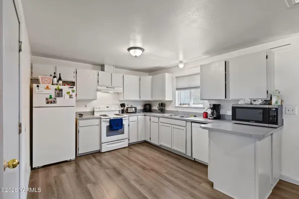 a kitchen with sink a microwave and cabinets