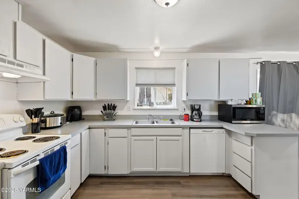 a kitchen with a sink a stove a microwave and cabinets