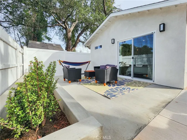 a view of a patio with table and chairs and potted plants