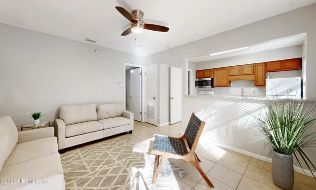 a living room with furniture ceiling fan and a rug