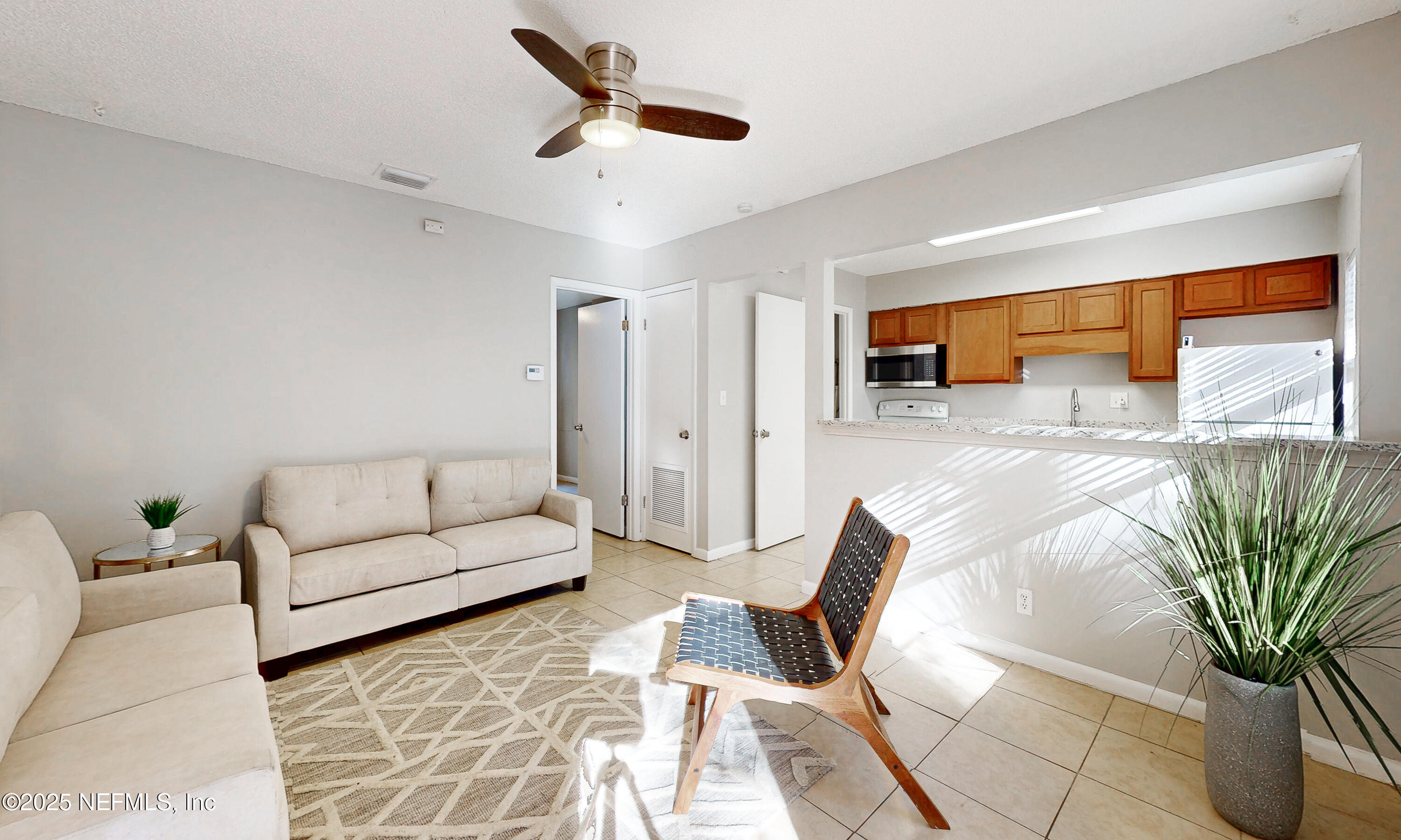a living room with furniture ceiling fan and a rug
